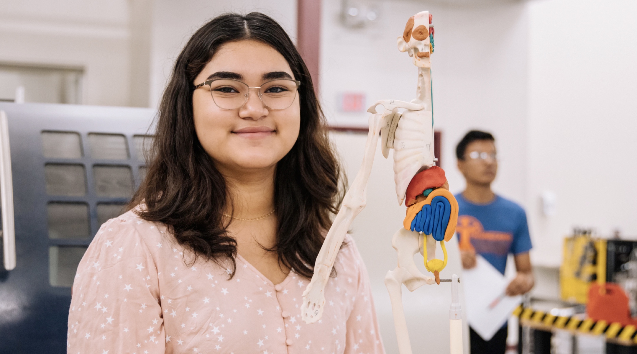 Student with skeleton in biology class